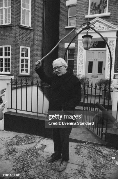 British Labour Party politician Michael Foot holding a walking stick in front of the entrance of a house, UK, 5th November 1980.