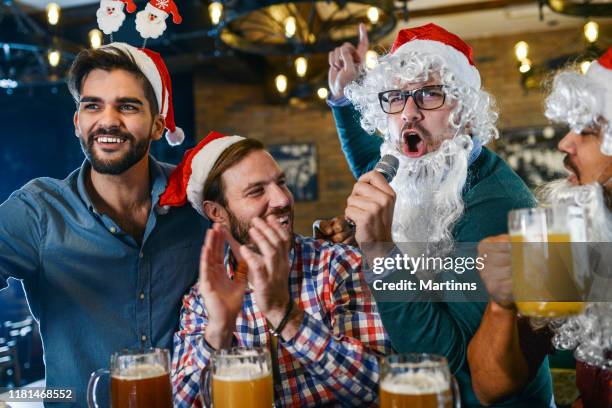 gruppo di amici che suonano karaoke al bar dopo il lavoro - music pub foto e immagini stock