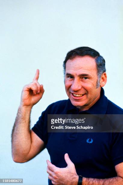 Portrait of American film director, actor, and comedian Mel Brooks, in a dark blue shirt, as he poses against a pale blue background, Los Angeles,...