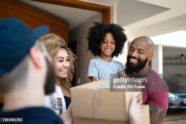 family receiving a delivery from the mailman - receiving package stock pictures, royalty-free photos & images
