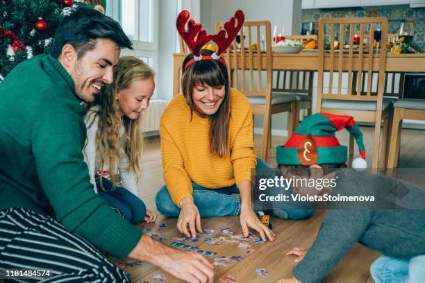 familie spelen met de nieuwe kerstcadeaus - legpuzzel stockfoto's en -beelden