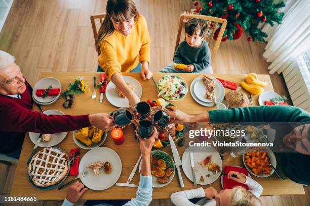 familie weihnachten toast - friends toasting above table stock-fotos und bilder