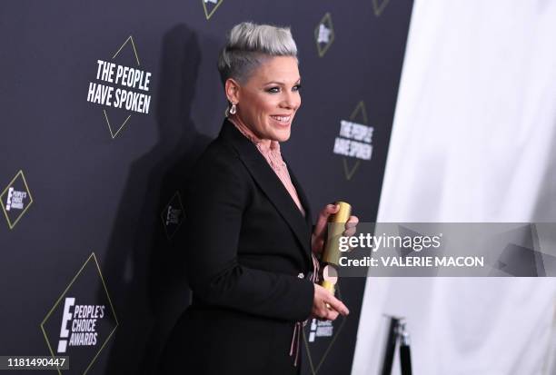 Singer/songwriter Pink poses with the People's Champion Award during the 45th annual E! People's Choice Awards at Barker Hangar in Santa Monica,...