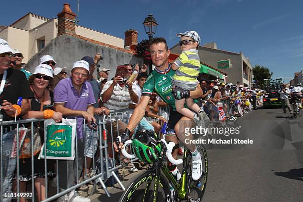 Thomas Voeckler of France and team Europcar carries his son after signing in ahead of Stage 3 of the 2011 Tour de France from Olonne sur Mer to Redon...