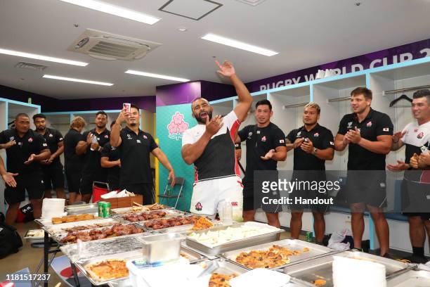 In this handout image provided by the Japan Rugby Union, captain Michael Leitch and Japanese players celebrate their victory in the dressing room...