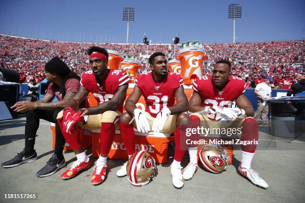 Antone Exum Jr. #38, Raheem Mostert and Matt Breida of the San Francisco 49ers sit on the sideline prior to the game against the Los Angeles Rams at...