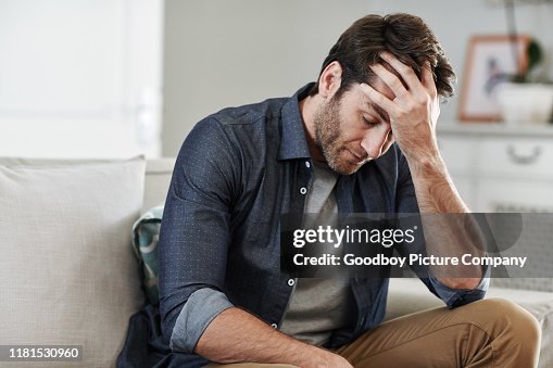 Hombre sentado solo en casa mirando triste y angustiado Hombre sentado solo en casa mirando triste y angustiado