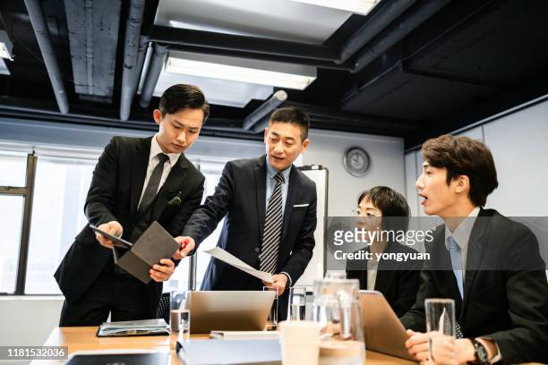 asian business team having a meeting in board room - yongyuan hongkong stock pictures, royalty-free photos & images