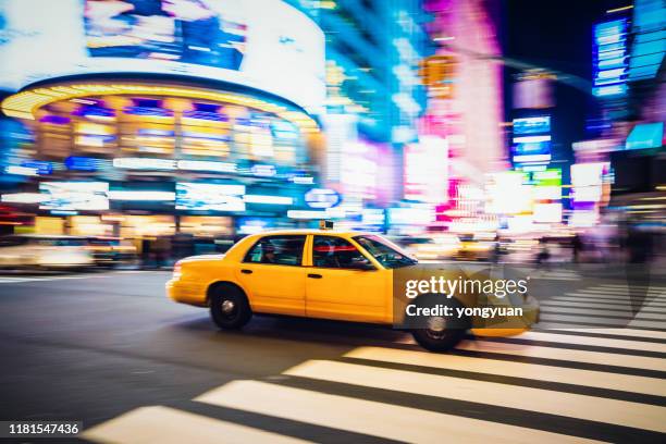gelbes taxi rast durch midtown manhattan - nyc cab stock-fotos und bilder