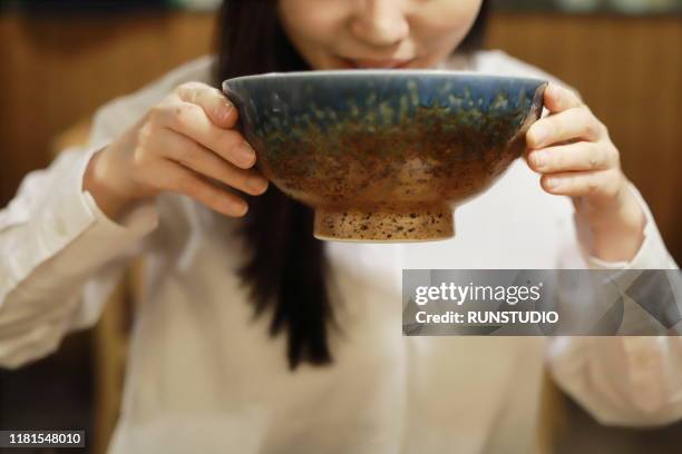 woman eating soup udon in restaurant - udon noodle stock pictures, royalty-free photos & images