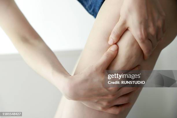 woman pinching thigh cellulite,close up - cellulite concept stock pictures, royalty-free photos & images