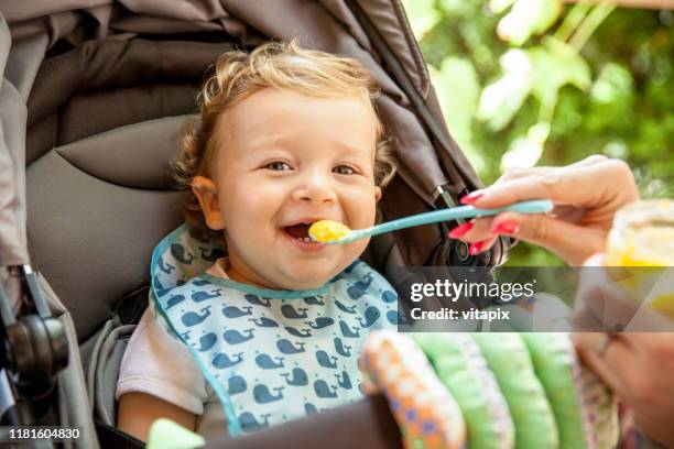 loving his baby food - mother baby food stock pictures, royalty-free photos & images