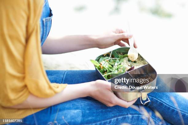 woman eating healthy lunch outdoors, close up. - lunchbox stockfoto's en -beelden