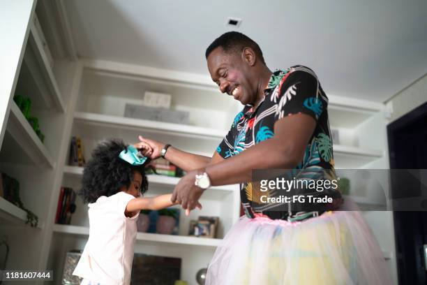 funny grandfather with tutu skirts dancing like ballerinas with grand daughter - stereotypical stock pictures, royalty-free photos & images