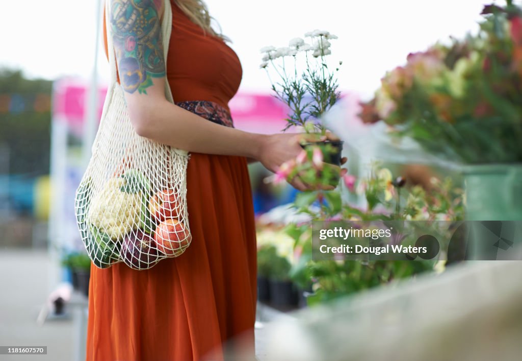 Woman shopping on local market with plastic free reusable bag.