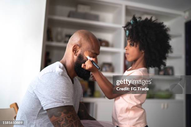 daughter doing makeup to shy father at home - children funny moments stock pictures, royalty-free photos & images