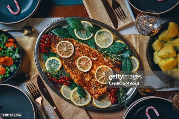cena di natale con filetto di pesce salmone, verdure, polenta e torta di natale - winter vegetables foto e immagini stock