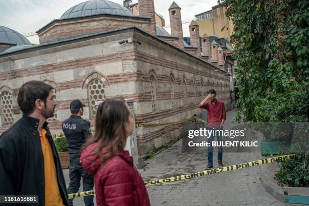 Bystanders look at the scene secured by the Turkish police in front of Mayday Rescue offices on November 11 in the Karakoy district of Istanbul. -...