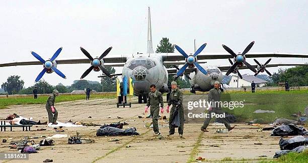 Ukrainian air force officers carry a body of a victim killed when Su-27 fighter plane crashed into a huge crowd of spectators at an air show in the...