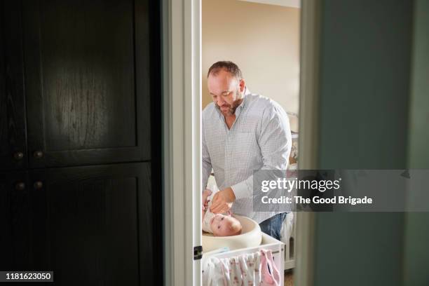 father changing diaper of baby girl - nappy change stockfoto's en -beelden