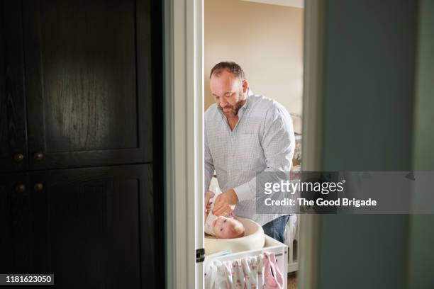 father changing diaper of baby girl - changing diaper stock pictures, royalty-free photos & images