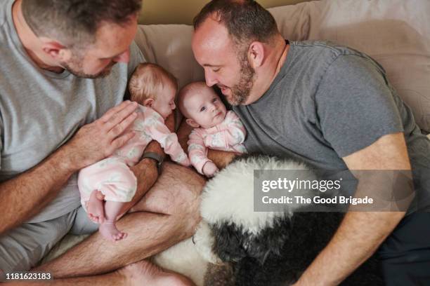 fathers lying in bed with baby girls and dog - monogamous animal behavior fotografías e imágenes de stock