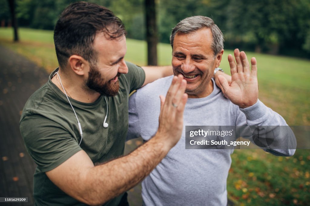 Man and son exercising in park together