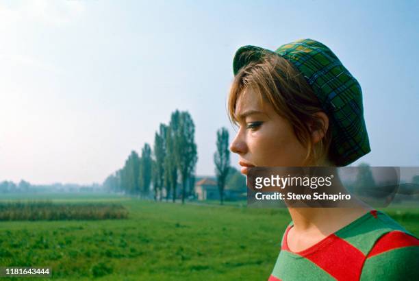 Portrait of French singer and actress Francoise Hardy, dressed in a green and red striped shirt and a cap, as she poses outdoors, Venice, Italy, 1966.