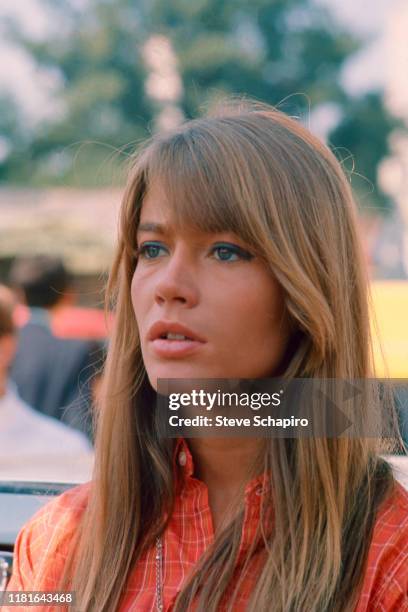 View of French singer and actress Francoise Hardy, in an orange, plaid shirt, as she poses outdoors, Venice, Italy, 1966.