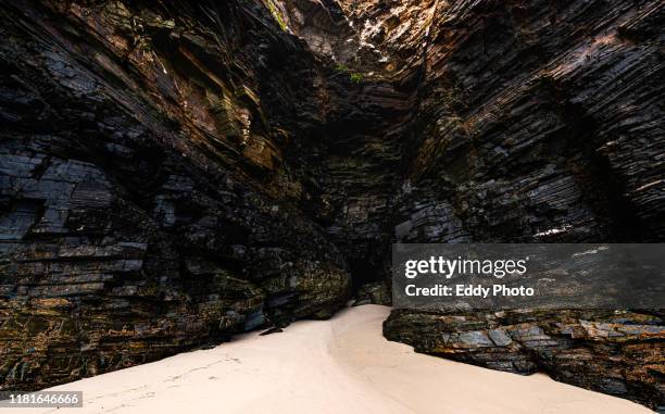 little cave entranceby the sea in spain - sharp rock formation stock pictures, royalty-free photos & images