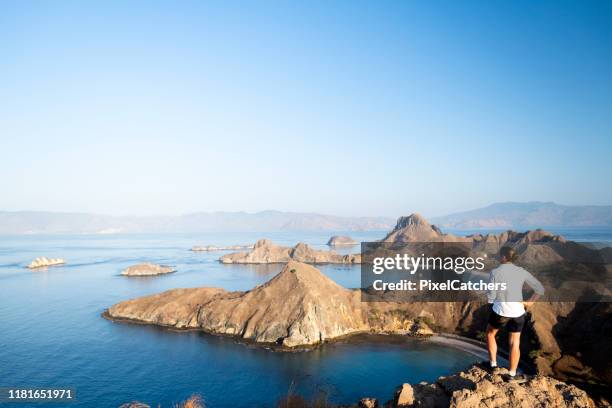 woman looks over islands scattered in the flores sea - flores stock pictures, royalty-free photos & images