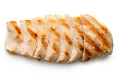 Partially sliced grilled chicken breast with grill marks, ground black pepper and salt isolated on white. Top view.