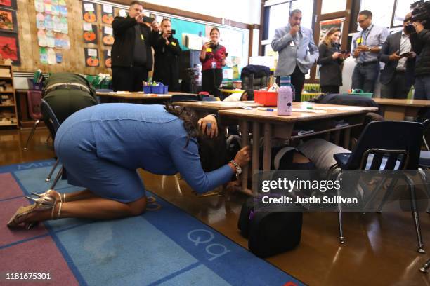San Francisco mayor London Breed ducks under a desk with Rosa Parks Elementary School students during the Great California Shakeout Earthquake Drill...