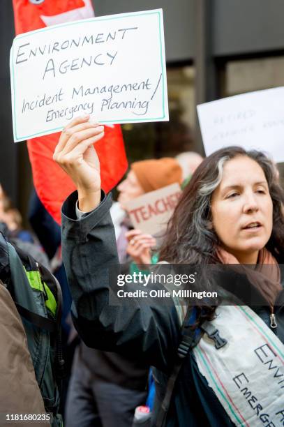 An Extinction Rebellion environmental activist and Environment Agency Incident Manager protests outside the offices of The Department of Working...