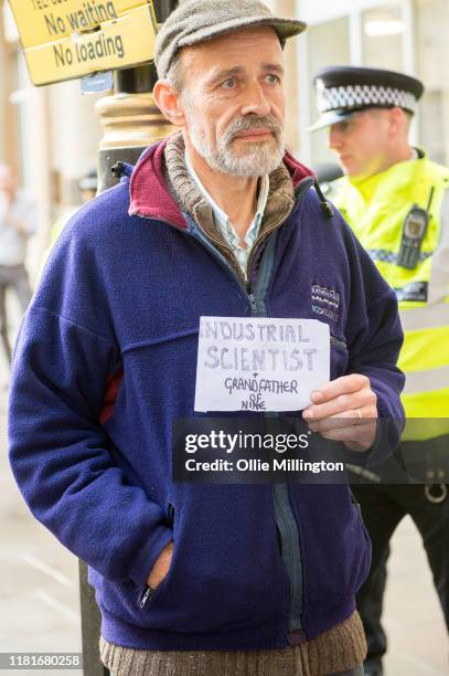 An Extinction Rebellion environmental activist and Industrial Scientist protests outside the offices of The Department of Working Pensions on October...