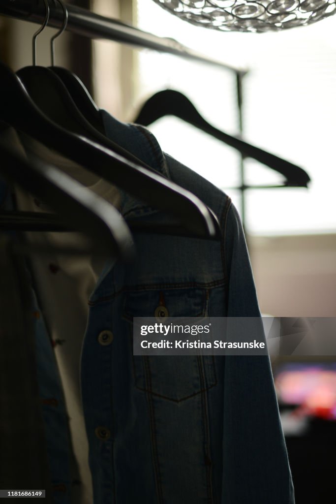 Some clothes hanging on hangers and some emtpy hangers