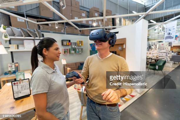 happy male customer trying out a virtual reality headset doing a virtual tour at a furniture home store - virtual showing stock pictures, royalty-free photos & images