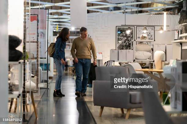 pareja de adoult medio caminando en una tienda de muebles mientras habla y sonríe - sala de muestras fotografías e imágenes de stock
