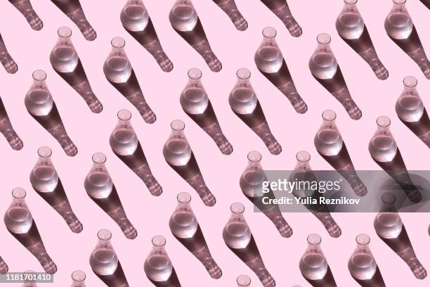 top view of beakers on the pink background - liquid medical stock-fotos und bilder