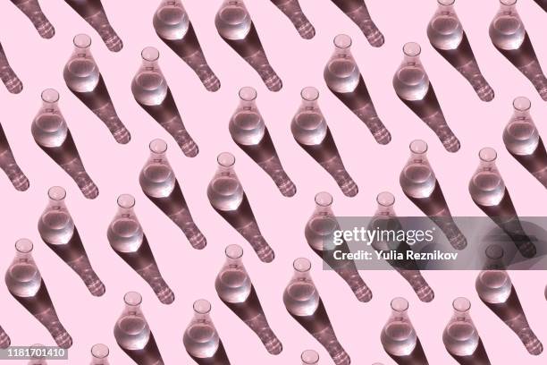 top view of beakers on the pink background - bottles glass top stockfoto's en -beelden