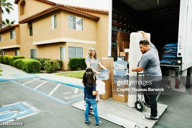 multigenerational family loading items onto liftgate of truck while moving - moving truck stock pictures, royalty-free photos & images