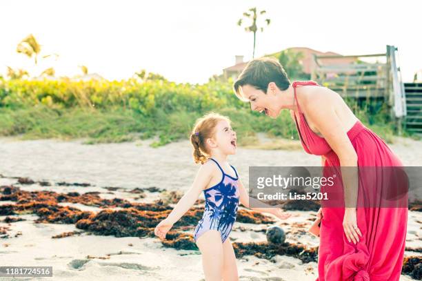 mooie moeder op het strand met redhead dochter candid en gelukkig wilde kind - boca raton stockfoto's en -beelden