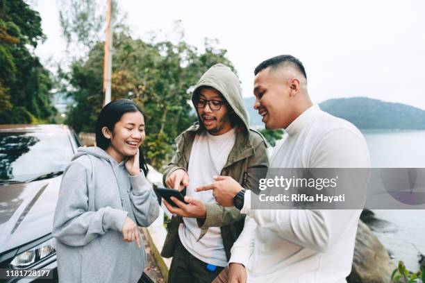 gruppe von freund im gespräch mit smartphone - indonesian ethnicity stock-fotos und bilder