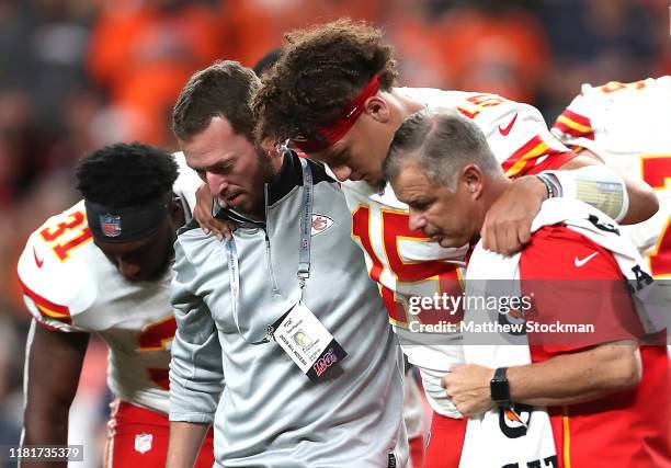Quarterback Patrick Mahomes of the Kansas City Chiefs is escorted off the field after an injury in the first half against the Denver Broncos in the...