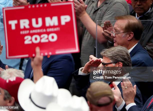 Secretary of Energy Rick Perry salutes U.S. President Donald Trump during a "Keep America Great" Campaign Rally at American Airlines Center on...