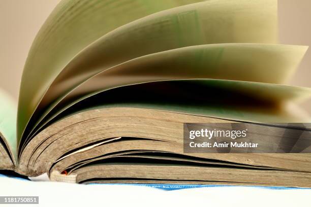 the open holy book (koran / quran) of allah - arabic script fotografías e imágenes de stock