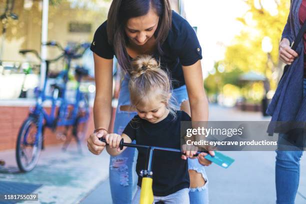 einkaufen für ein fahrrad mit kreditkarte zwei schöne frauen junge millennial und reife generation x und jungeweibliche kind in western colorado an einem hellen sonnigen tag - stützrad stock-fotos und bilder