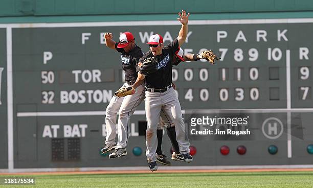 Rajai Davis, Eric Thames, and Travis Snider of the Toronto Blue Jays celebrate a 9-7 win over the Boston Red Sox at Fenway Park on July 4, 2011 in...