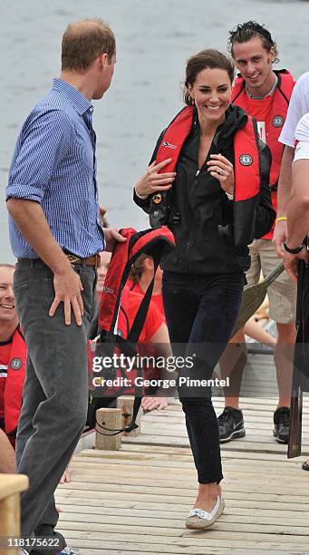 Prince William, Duke of Cambridge and Catherine, Duchess of Cambridge arrive on shore after rowing dragon boats across Dalvay lake on July 4, 2011 in...