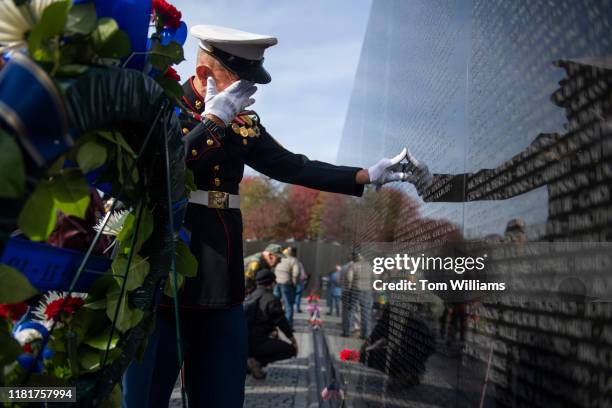 Retired Marine Paul Masi, of Bethpage, N.Y., pauses by the name of his high school classmate, Robert Zwerlein, at the Vietnam Veterans Memorial on...